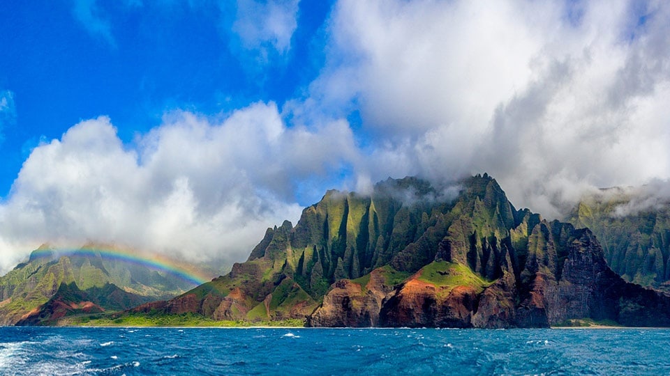 A view of Maui in Hawaii with a clouds and rainbow