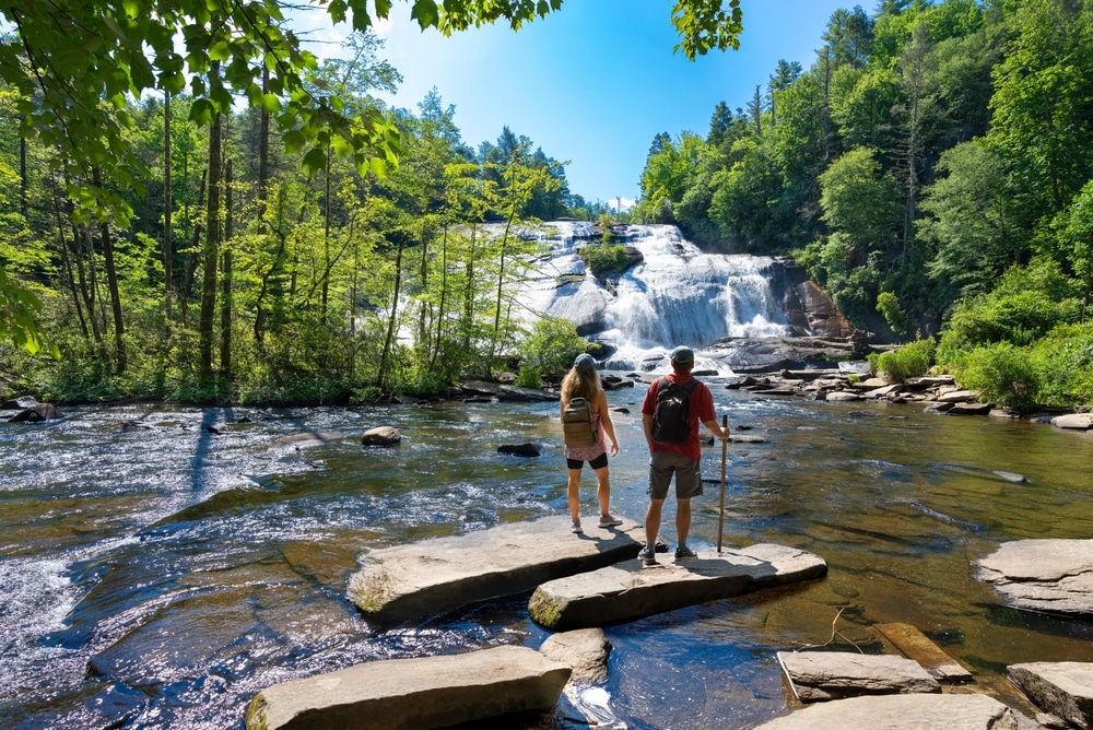 Couple Standing On The Rock Enjoying Beautiful Waterfall View friends Relaxing