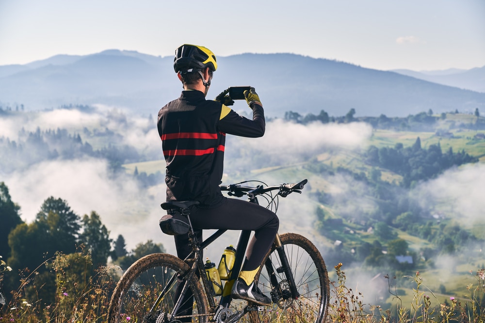 Back View Of Man Sitting On Bicycle And Talking Mountain