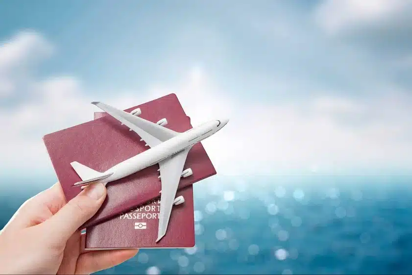 a women holding the passports along with the mini toy plane