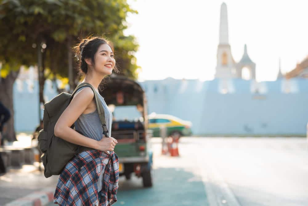 girl is smiling while standing on the road side