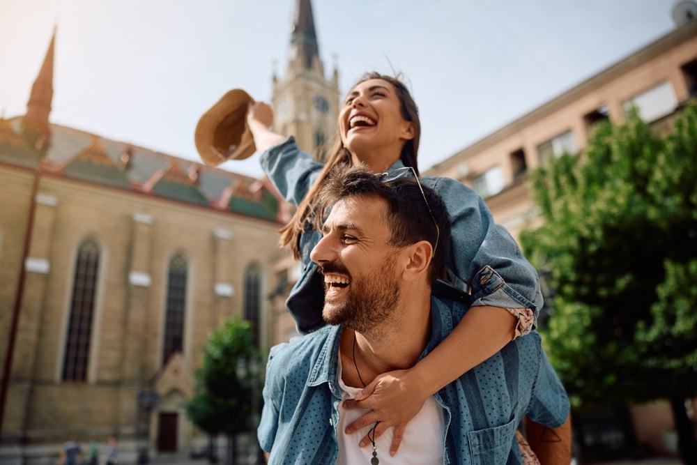 Young Carefree Couple Piggybacking While Traveling