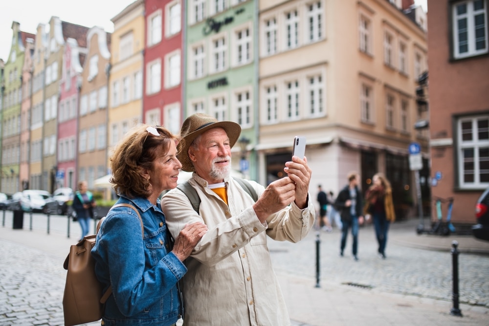 Portrait Of Happy Senior Couple Tourists Doing Selfie Outdoors In